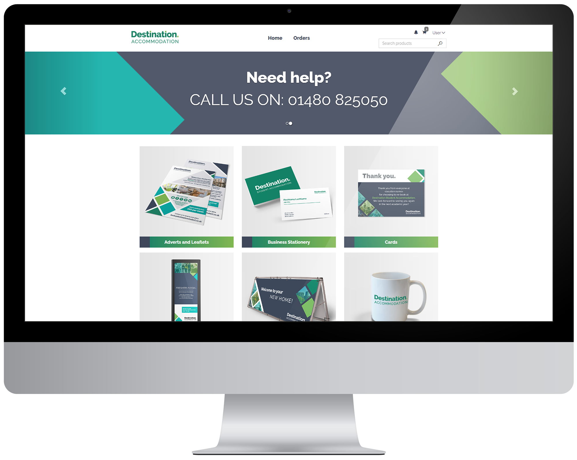 A computer monitor displaying a website for Destination Accommodation, showcasing various promotional materials like leaflets, business stationery, greeting cards, a mobile view, a signboard, and a mug with the company's branding.